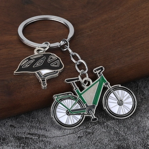 Detailed close-up of a green bicycle keychain and a black cycling helmet pendant