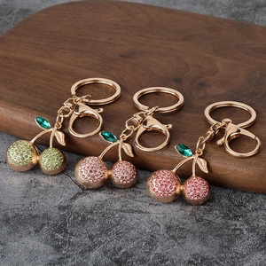 Sparkling crystal cherry keychains in gold finish with metal lobster clasps for bags