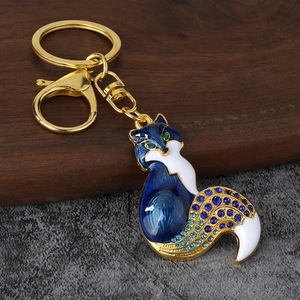 Detailed close-up of blue enamel fox keychain with sparkling crystals and gold metal finish