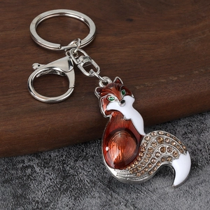 Detail of fox keychain with orange enamel and sparkling brown rhinestones on metal clasp