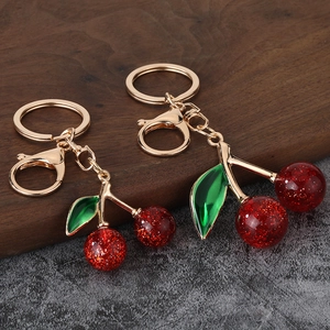 Detailed close-up of cherry keychain featuring red sequined resin fruit and golden lobster clasp