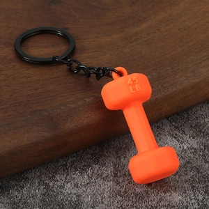 Creative orange dumbbell keychain with 45 LB weight detail on dark wooden surface