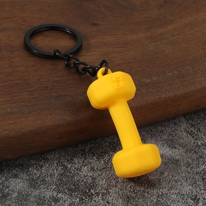 Detailed view of yellow 45 LB dumbbell keychain with matte texture and black metal ring