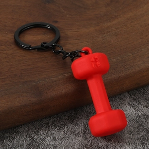 Macro detail of red 45 LB dumbbell keychain with matte finish on textured background