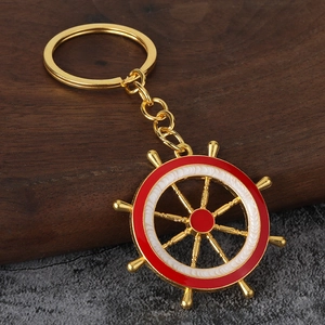 Porte-clés nautique en forme de gouvernail doré avec émail rouge et blanc sur bois