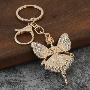 Detailed close-up of golden ballet fairy keychain with sparkling white rhinestones