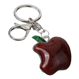 Sparkling red apple keychain with silver metal base and lobster clasp on white background