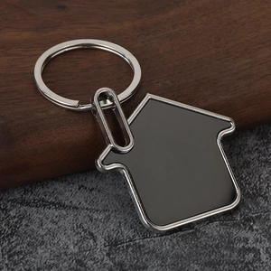 Macro detail of house-shaped metal bottle opener keychain on rustic wooden background