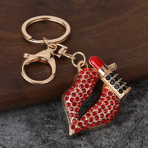 Close-up of sparkling rhinestone red lips and lipstick keychain with gold metal finish