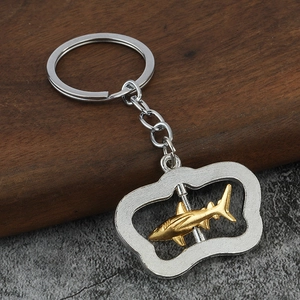 Macro shot of spinning golden shark pendant keychain with rotating metal structure