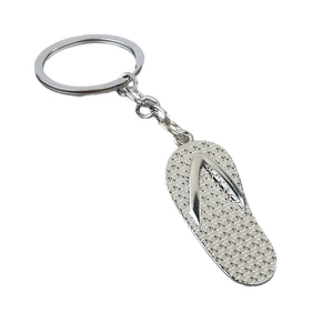 Silver metal flip-flop keychain with textured sole and smooth straps on white background