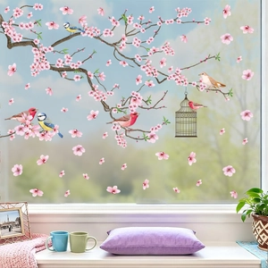 Detail von rosa Kirschblüten- und Vogel-Fensteraufklebern auf heller Glasscheibe