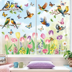 Detail of floral and bird static window decals applied on glass with garden background