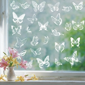 Detailed view of white butterfly static window clings on glass with a garden background