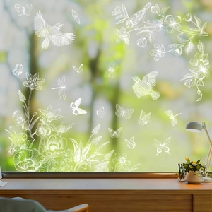 Detailed view of white floral and butterfly window clings on transparent glass