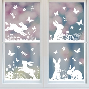 Stickers de Pâques avec silhouettes de lapins blancs et fleurs sur une fenêtre en bois