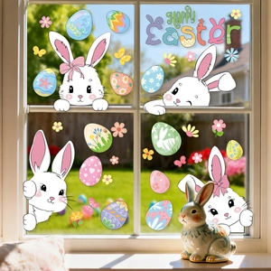 Detailed view of white cartoon bunnies and colorful Easter eggs stickers on window glass