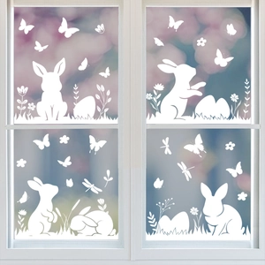 Easter window decals featuring white bunnies, flowers and eggs on glass pane with spring view