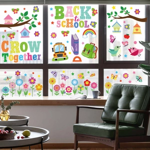 Detailed view of colorful Back to School window stickers with cartoon birds and bus on glass