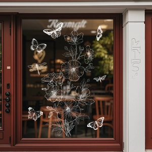 Details von weißen Blumen- und Schmetterlings-Fensteraufklebern an einem Café