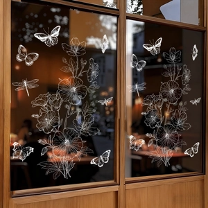Detailansicht der weißen Fensteraufkleber mit Blumen und Schmetterlingen auf einer Glasscheibe