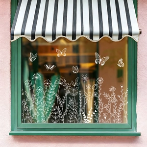 White butterfly and floral line-art window stickers on shop glass window with awning