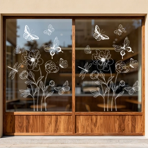 White hand-drawn butterfly and flower static window decals on a glass shop window