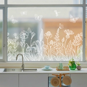 Detail of white hand-drawn floral and butterfly window clings on a glass kitchen window