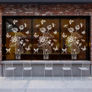 Detailed white line art window stickers with lotus and butterfly on glass storefront