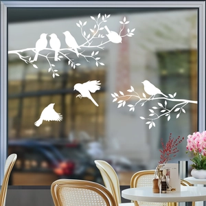 Close-up of elegant white bird and branch window stickers applied on glass panes