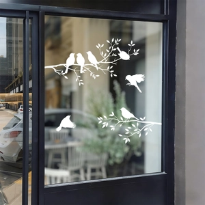 Detailed view of white bird and branch static window stickers on a glass panel