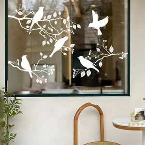 Detail view of white bird and branch static window decals in a bright interior setting