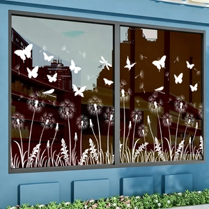 Detailed view of white dandelion and butterfly window decals applied on glass panes