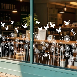 Detail of white dandelion and dragonfly static window decals on a shop glass window