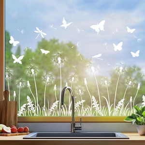 Detail of white butterfly and dandelion static window film on glass in bright kitchen