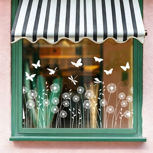 Detailed white dragonfly and dandelion static window stickers on vintage green frame