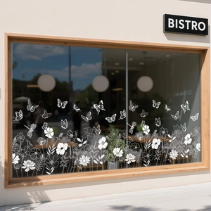 Close-up of white floral and butterfly window film on a minimalist bistro glass window