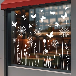 Détail d'autocollants statiques blancs de papillons et pissenlits sur une vitre de café