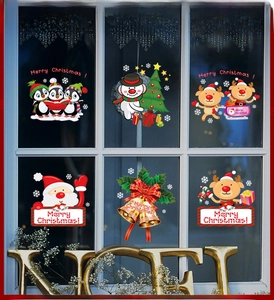 Close-up of Christmas window decals featuring Santa and reindeer on glass with Noel decor
