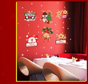 Festive Christmas window stickers set with Santa, reindeer, snowman and penguin on red wall