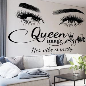 Queen wall decal with crown and eyes above gray sofa in modern living room setting