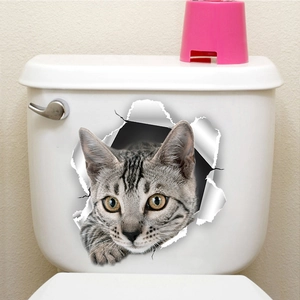 3D cat toilet sticker showing a gray tabby peeking through a broken hole on a tank