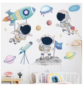 Nursery wall sticker detail showing space astronauts and planets in soft macaque colors
