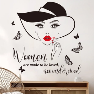 Detail of woman silhouette wall sticker with butterflies and cursive quote on a white wall