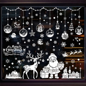 Close-up of white Christmas window stickers featuring reindeer and snowflakes on glass
