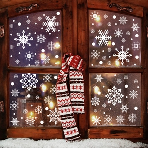 Close-up of white snowflake window clings on a rustic wooden frame for Christmas