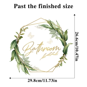 Detail view of green leaf wreath bathroom sticker with golden text and dimensions