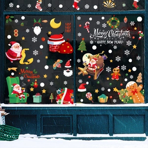Christmas window decals with Santa Claus and gingerbread man on a snowy storefront glass