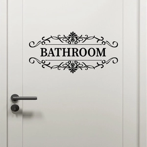 Close-up of black adhesive vinyl bathroom door sticker with elegant scroll pattern