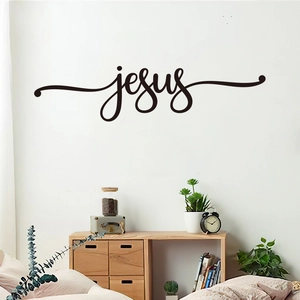 Macro detail of black vinyl Jesus wall decal sticker on a minimalist bedroom interior wall